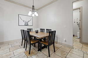 Dining room featuring a notable chandelier and ornamental molding