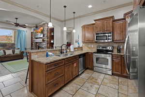 Kitchen featuring stainless steel appliances, sink, a kitchen bar, kitchen peninsula, and hanging light fixtures