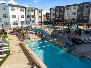 View of pool with a water slide and a patio area