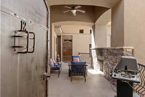 View of patio / terrace featuring ceiling fan and a fireplace