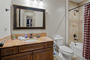 Full bathroom with toilet, shower / tub combo, vanity, and tile patterned floors