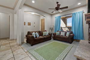 Living room featuring ceiling fan and crown molding