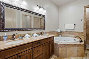 Bathroom with tiled tub and vanity