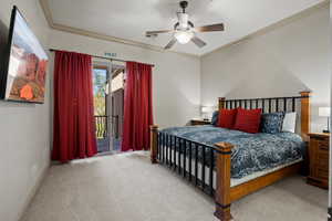 Carpeted bedroom with ceiling fan, access to outside, and ornamental molding