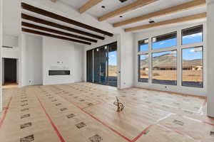 Unfurnished living room featuring beamed ceiling and a mountain view