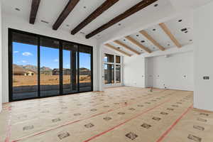 Unfurnished living room with vaulted ceiling with beams