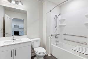 Full ADA bathroom featuring shower / bathing tub combination, grab bars and bench, vanity, and toilet