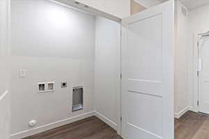 Laundry room with dark hardwood / wood-style flooring, hookup for a washing machine, and electric dryer hookup