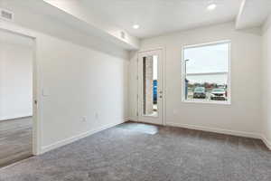 Empty room with a textured ceiling and carpet flooring