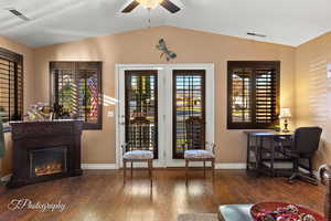 Interior space featuring dark wood-type flooring, ceiling fan, and vaulted ceiling