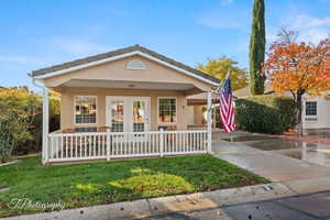 View of front of home with a porch and a front yard