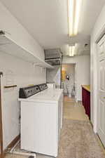 Laundry room with a textured ceiling and washing machine and dryer