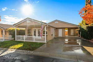 Ranch-style home featuring covered porch and a carport