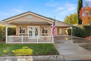 Single story home featuring a porch and a carport