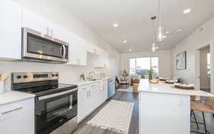 Kitchen with white cabinetry, appliances with stainless steel finishes, and a kitchen island