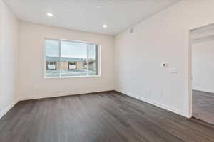 Empty room featuring dark hardwood / wood-style floors