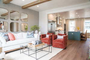 Living room with V-grooving and beamed ceiling, hardwood / wood-style flooring, and  wallpaper