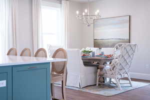 Dining area featuring an inviting chandelier and hardwood / wood-style flooring