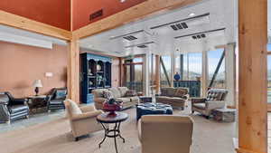 Carpeted living room with a mountain view and expansive windows