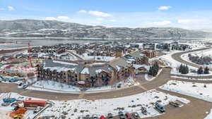 Snowy aerial view featuring a water and mountain view