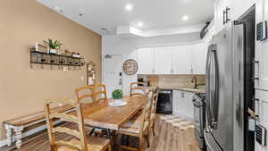 Kitchen featuring light stone countertops, stainless steel appliances, a barn door, white cabinetry, and sink