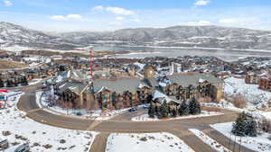 Snowy aerial view featuring a water and mountain view