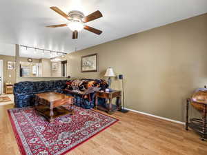 Living room with ceiling fan and light wood-type flooring