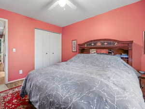 Bedroom featuring ceiling fan, light hardwood / wood-style flooring, and a closet