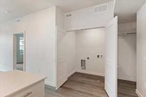 Laundry area with hardwood / wood-style floors, hookup for an electric dryer, and hookup for a washing machine