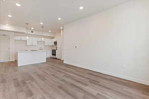 Unfurnished living room with sink and light hardwood / wood-style flooring