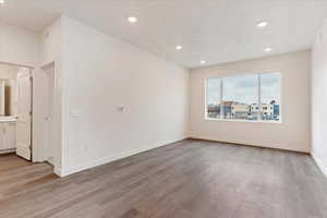 Spare room featuring a textured ceiling and light hardwood / wood-style floors