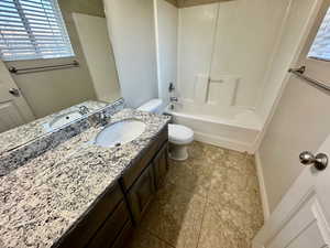 Full bathroom featuring tub / shower combination, vanity, and toilet