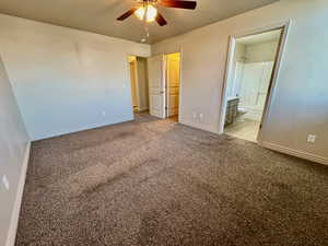 Unfurnished bedroom with ensuite bath, ceiling fan, and light carpet