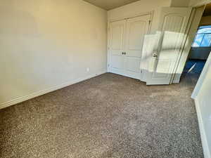 Unfurnished bedroom featuring a closet and carpet floors