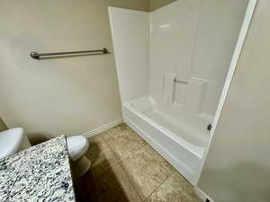 Bathroom with  shower combination, tile patterned floors, and toilet