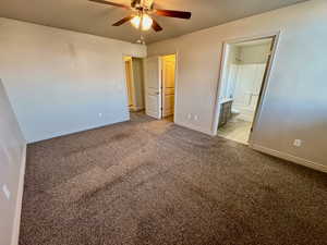 Unfurnished bedroom featuring ceiling fan, ensuite bathroom, and light carpet