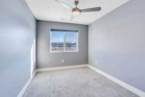 Empty room featuring ceiling fan, light carpet, and a textured ceiling