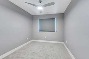 Empty room featuring ceiling fan and light colored carpet