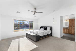 Bedroom with lofted ceiling, ensuite bathroom, ceiling fan, and carpet