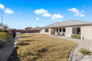 Back of house featuring a lawn and a patio area