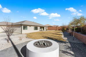 Rear view of property with an outdoor fire pit, a yard, and a patio