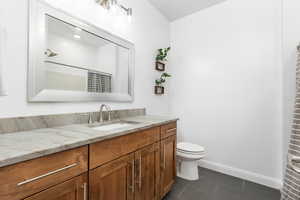 Bathroom with a shower with shower curtain, tile patterned flooring, vanity, and toilet