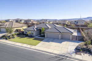 View of front facade featuring a garage, a mountain view, and a front lawn