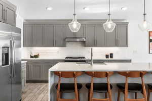 Kitchen with stainless steel appliances, sink, and gray cabinetry