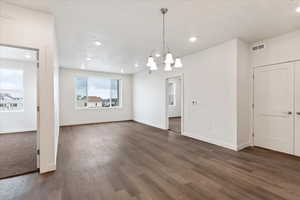 Interior space featuring a notable chandelier and dark wood-type flooring