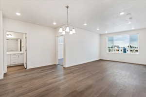 Interior space with a textured ceiling, a notable chandelier, and dark wood-type flooring