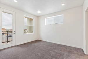 Carpeted spare room with a textured ceiling