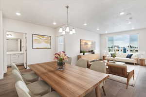 Dining space with an inviting chandelier and dark hardwood / wood-style flooring