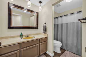 Bathroom with toilet, hardwood / wood-style flooring, walk in shower, and vanity