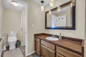 Owners Bathroom with toilet, wood-type flooring, and vanity